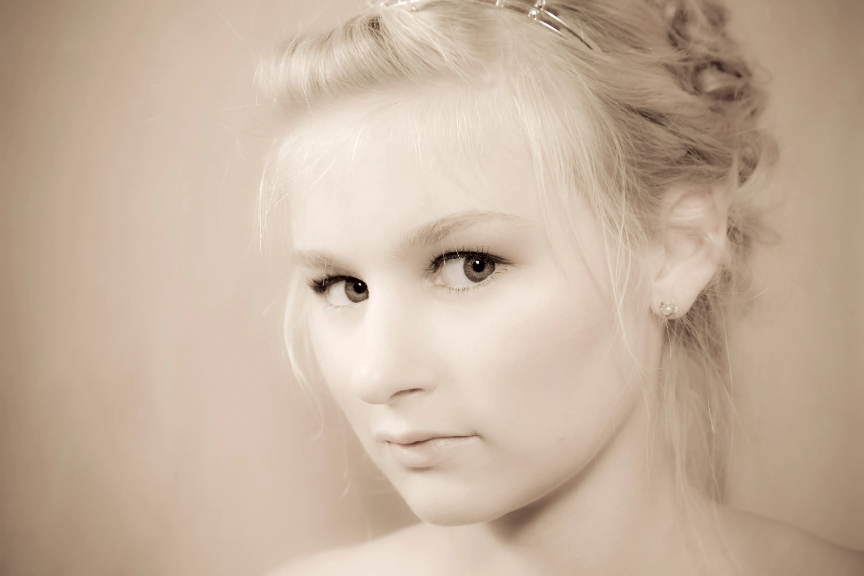 Emily with light hair styled in an updo, looking at the camera.