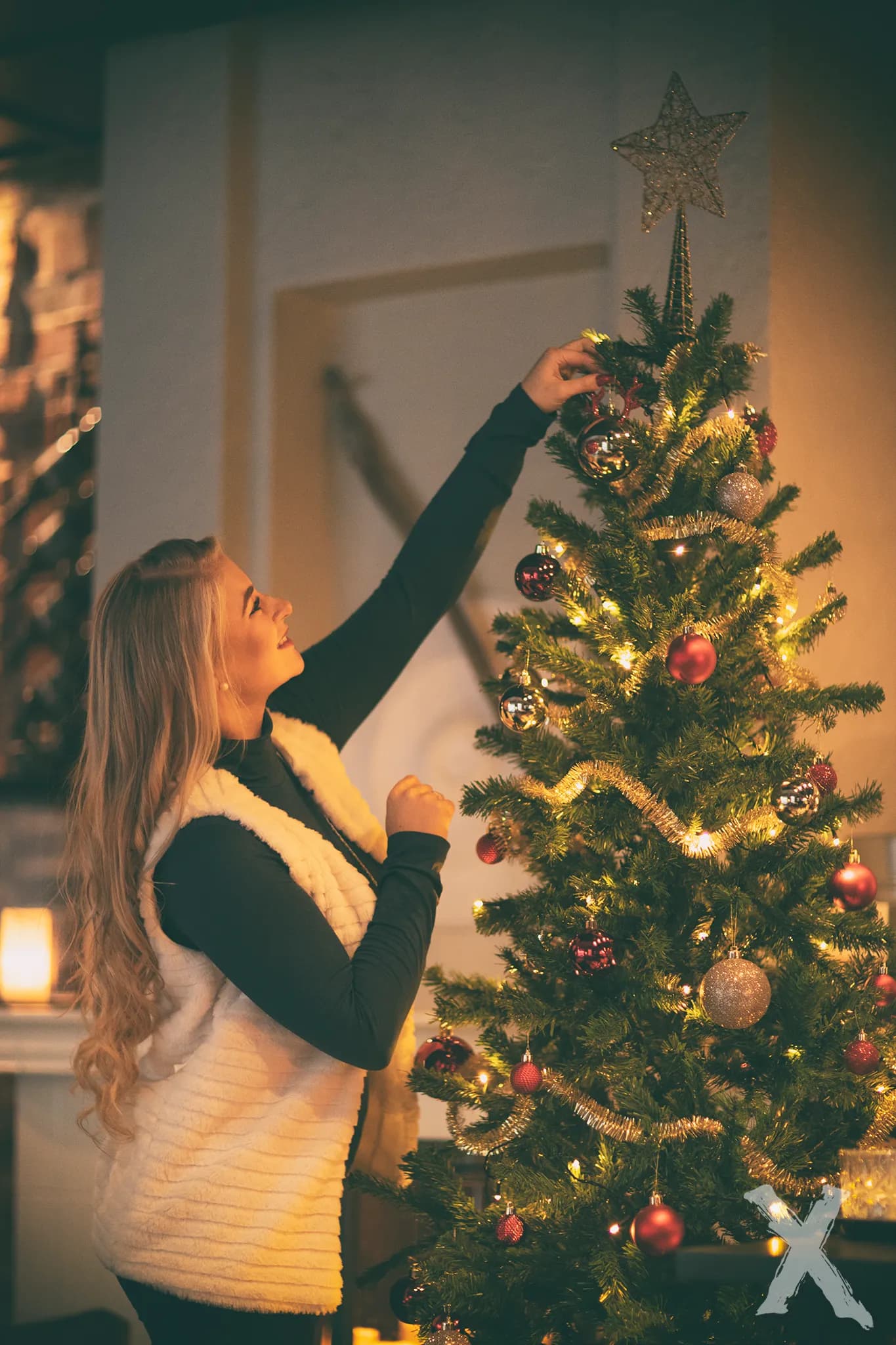 Emily decorates a Christmas tree with ornaments.